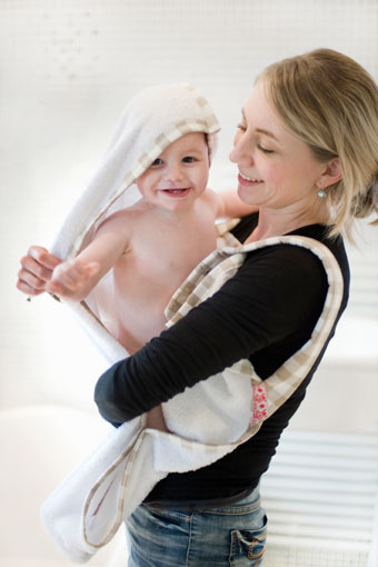 Lachende baby bij mama in badhanddoek